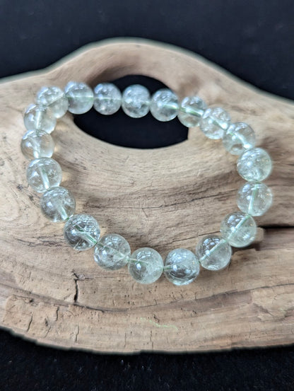 10mm Green Amethyst (Prasiolite) Bracelet, showing pale mint colour and delicate internal inclusions on driftwood.