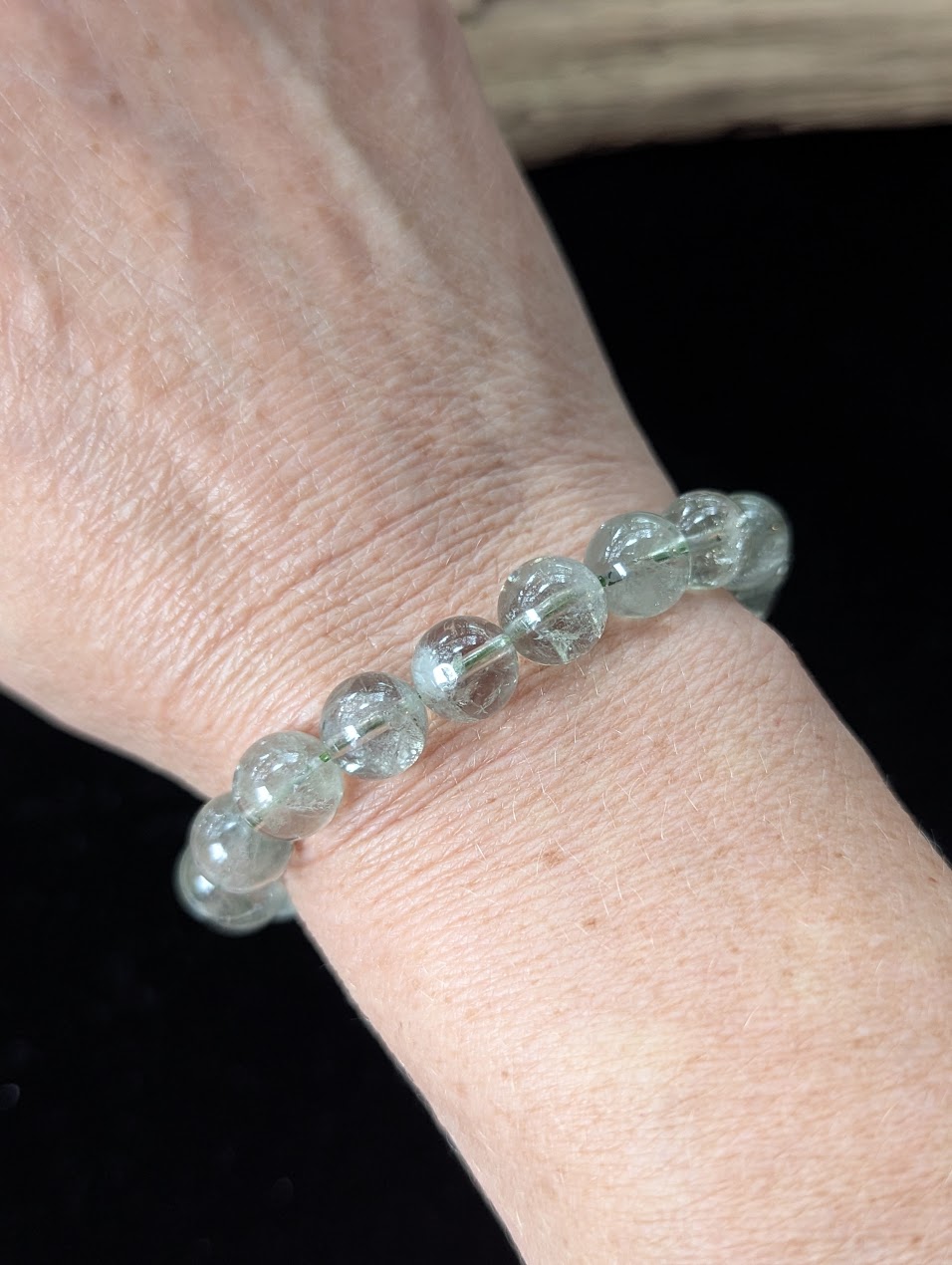 10mm Green Amethyst (Prasiolite) Bracelet shown worn on a wrist, illustrating scale and transparency.