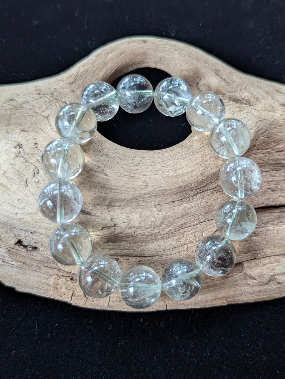 14mm Green Amethyst (Prasiolite) Bracelet, showing pale mint colour and delicate internal inclusions on driftwood.