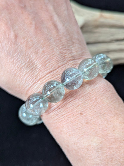 14mm Green Amethyst (Prasiolite) Bracelet shown worn on a wrist, illustrating scale and transparency.