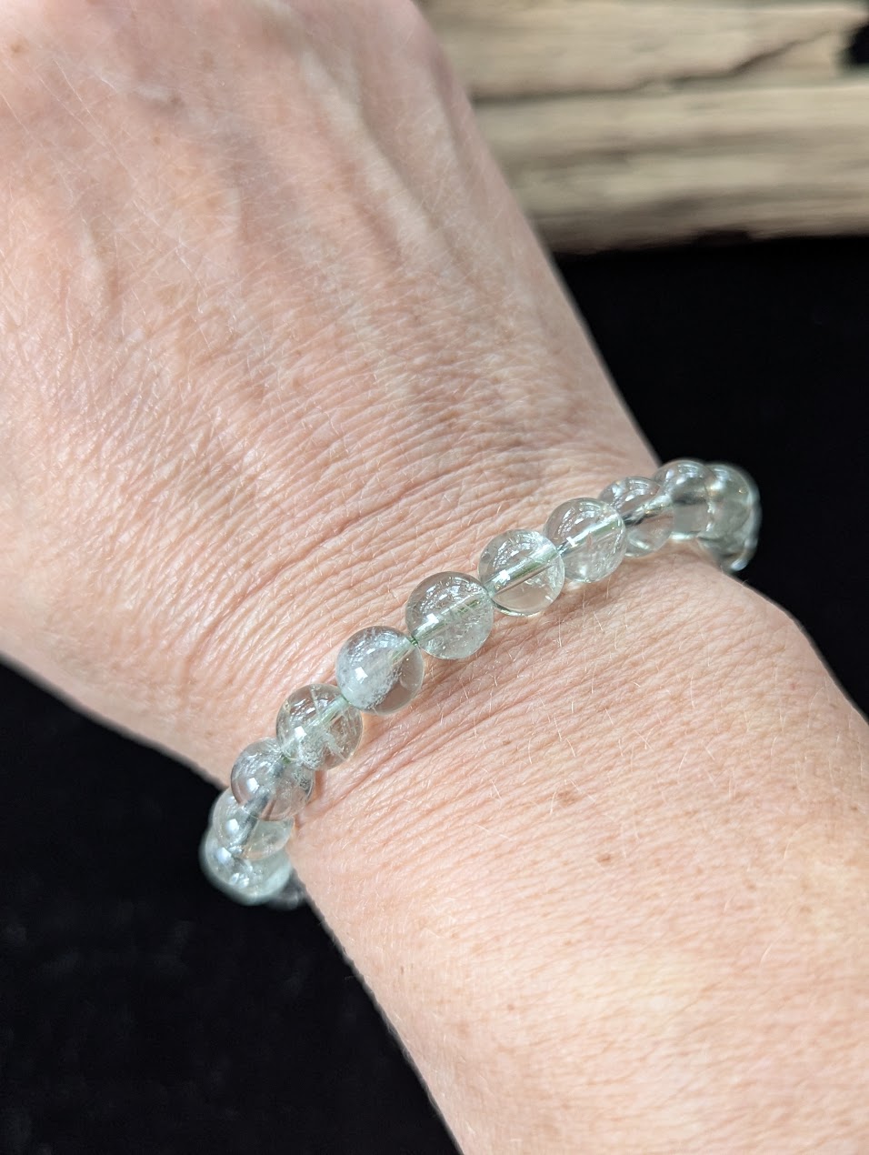 8mm Green Amethyst (Prasiolite) Bracelet shown worn on a wrist, illustrating scale and transparency.