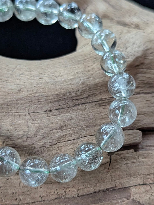 9mm Green Amethyst (Prasiolite) Bracelet, showing pale mint colour and delicate internal inclusions on driftwood.