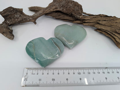 Top down view of two polished Green Aventurine hearts.