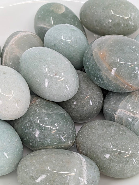 Close-up of Green Aventurine tumbled stones showing fine fuchsite mica shimmer and smooth polished surface