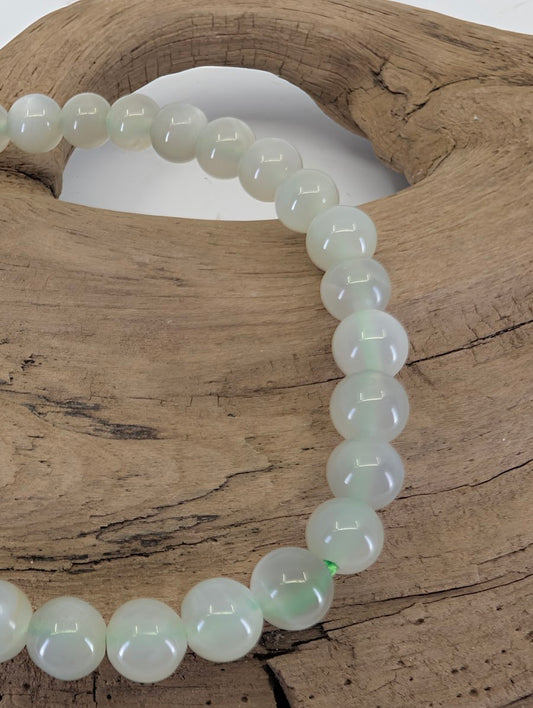 Close-up of 6mm Green Moonstone beads highlighting the natural adularescence and pearly luster.