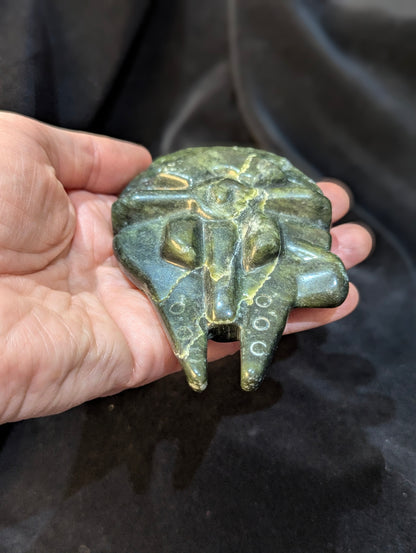 Hand holding a carved green Nephrite Jade Millennium Falcon to demonstrate size and scale