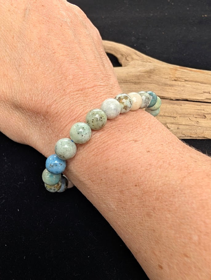 8mm polished Hackmanite beaded stretch bracelet worn on a wrist for size scale.