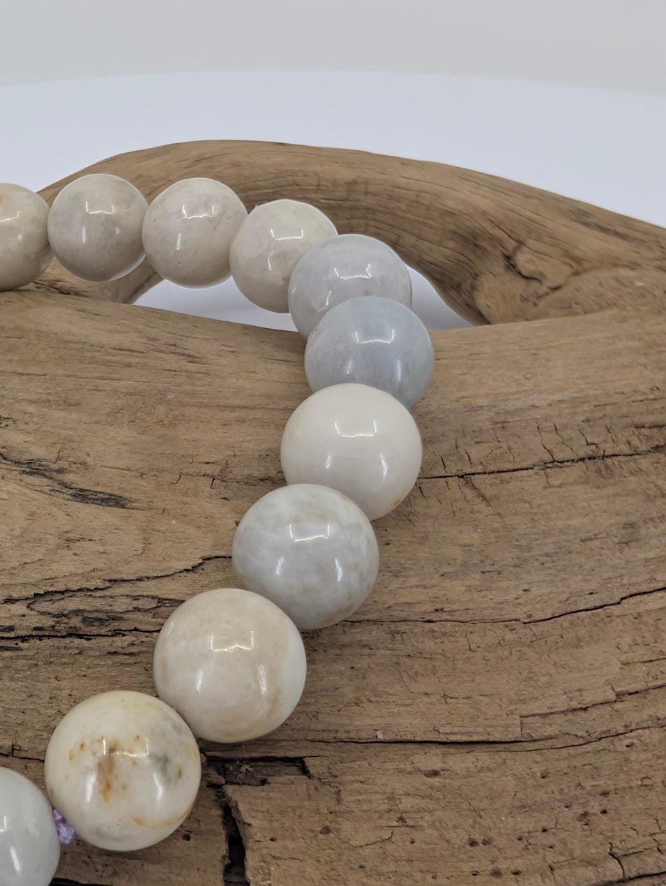 Close-up of polished 8mm hackmanite beads with natural marbling and inclusions