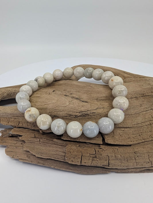 8mm hackmanite bracelet on driftwood showing neutral grey and white beads
