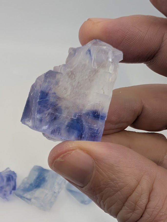Halite specimen showing rich blue streaks and raw cubic surfaces
