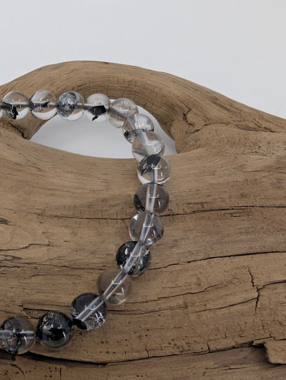 Macro photo of high clarity Herkimer style quartz beads with anthraxolite inclusions