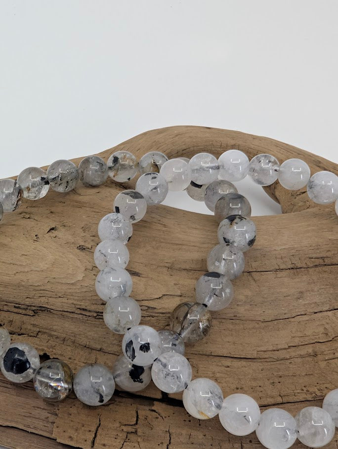 Macro photo of Herkimer style quartz beads with black anthraxolite inclusions