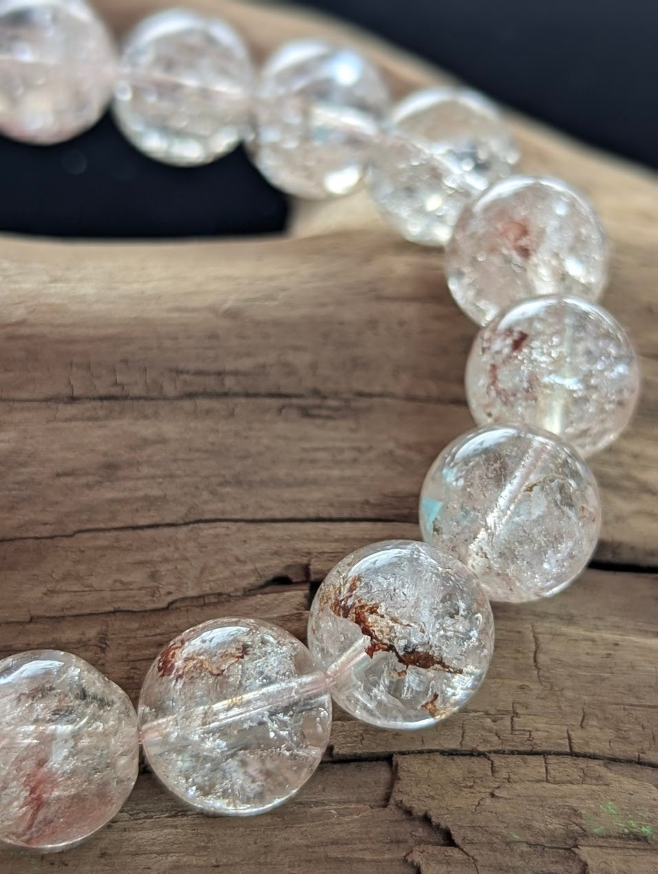 Macro photograph of 12mm Himalayan Garden Quartz beads highlighting the flawless lapidary polish and internal lodolite structures.