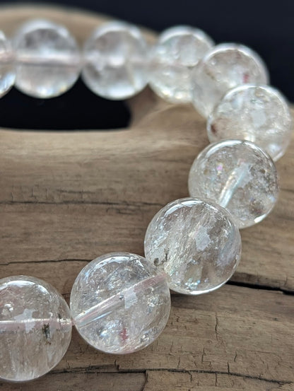 Macro photograph of 14mm Himalayan Garden Quartz beads highlighting the optical perfection and distinct natural lodolite inclusions