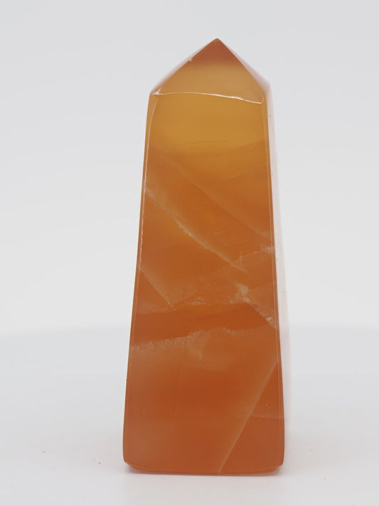 Polished Honey Calcite tower from Pakistan featuring vibrant amber-orange translucency and natural internal veils.