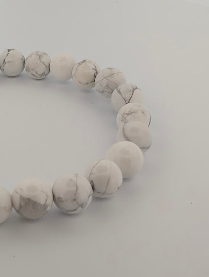 Angled close-up of 8mm Howlite round beads with polished finish and natural veining