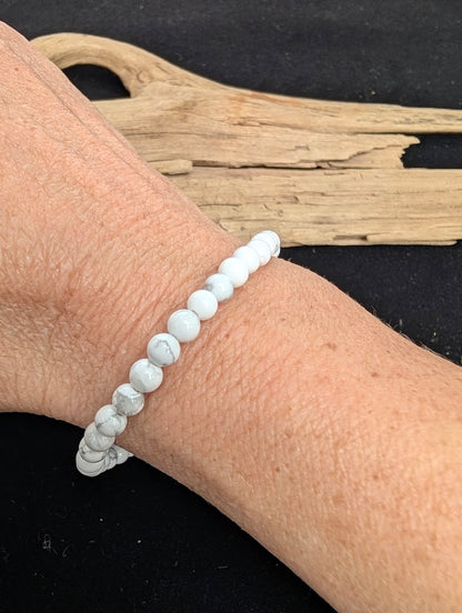 4mm smooth Howlite beaded stretch bracelet worn on a wrist for delicate size scale.