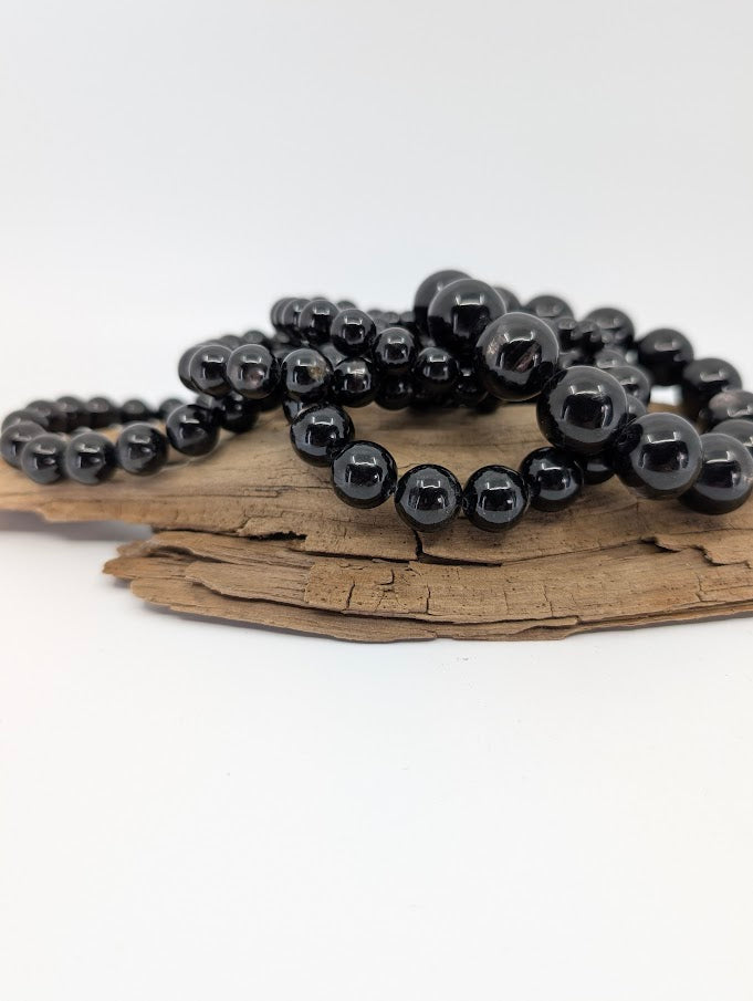 High quality Hypersthene bracelets displayed on wood showing metallic sheen and deep black colour