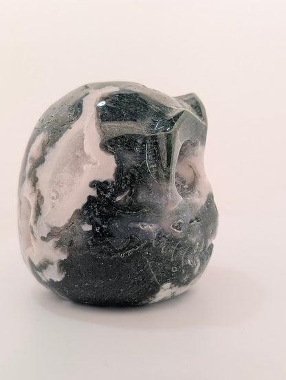side view of Moss Agate Jack Skellington carving showing green dendritic “moss” inclusions and glossy polish