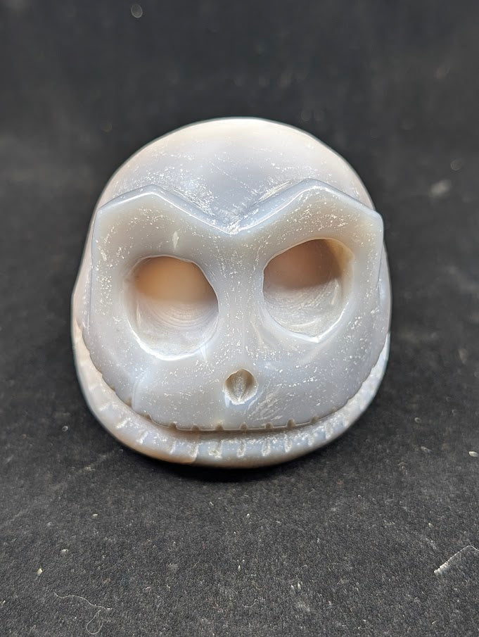 Detail of Ocean Agate Jack Skellington carving showing soft grey banding and glossy polish Top view