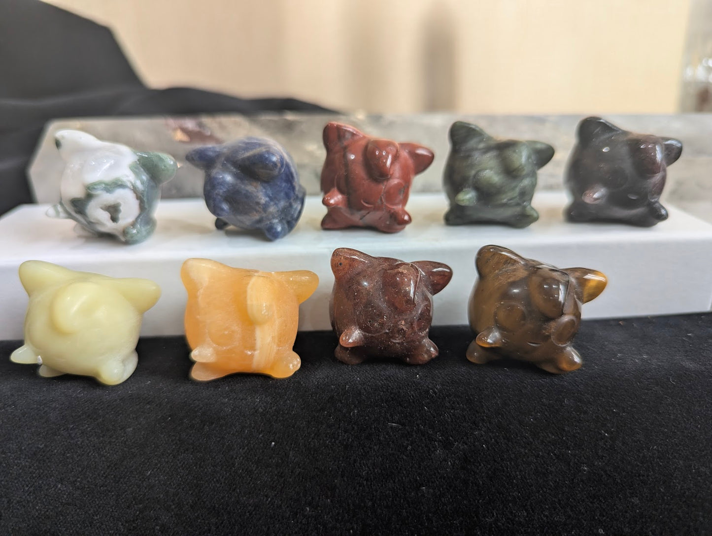 A group of hand-carved Jigglypuff Pokémon totems in assorted natural minerals.