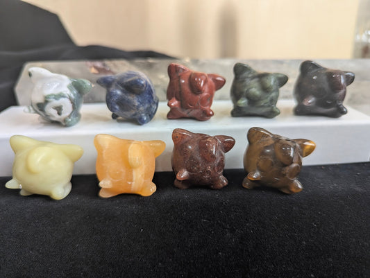 A group of hand-carved Jigglypuff Pokémon totems in assorted natural minerals.