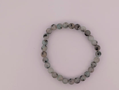 Overhead view of Kiwi Jasper 8mm bracelet on light background