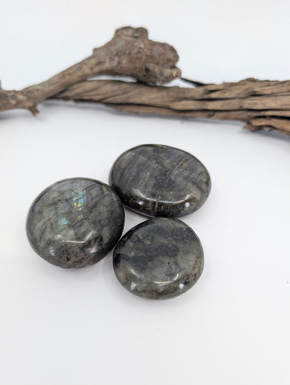 Labradorite palm stone polished showing dark feldspar with natural flash