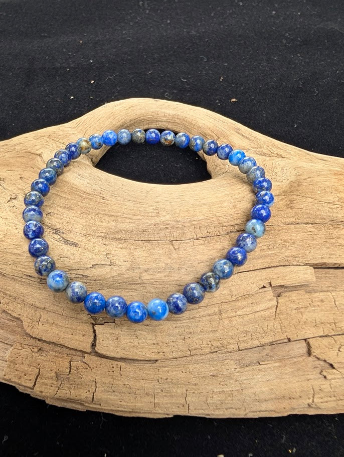 4mm polished Lapis Lazuli beaded stretch bracelet worn on a wrist for delicate size scale.