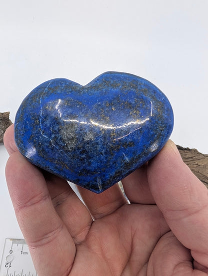 Hand holding a 160g Lapis Lazuli heart showing pyrite sparkles.