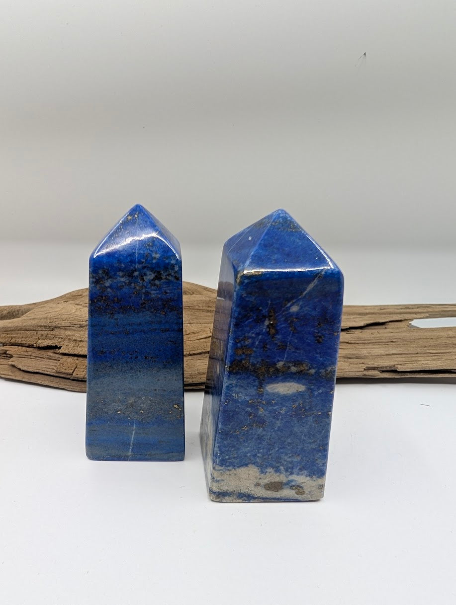 Two standing Lapis Lazuli crystal points displaying variations in blue saturation and natural calcite banding.