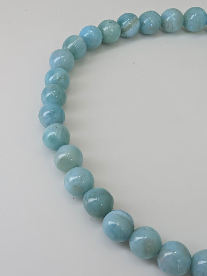 Detailed view of Larimar beads highlighting polish and natural pattern
