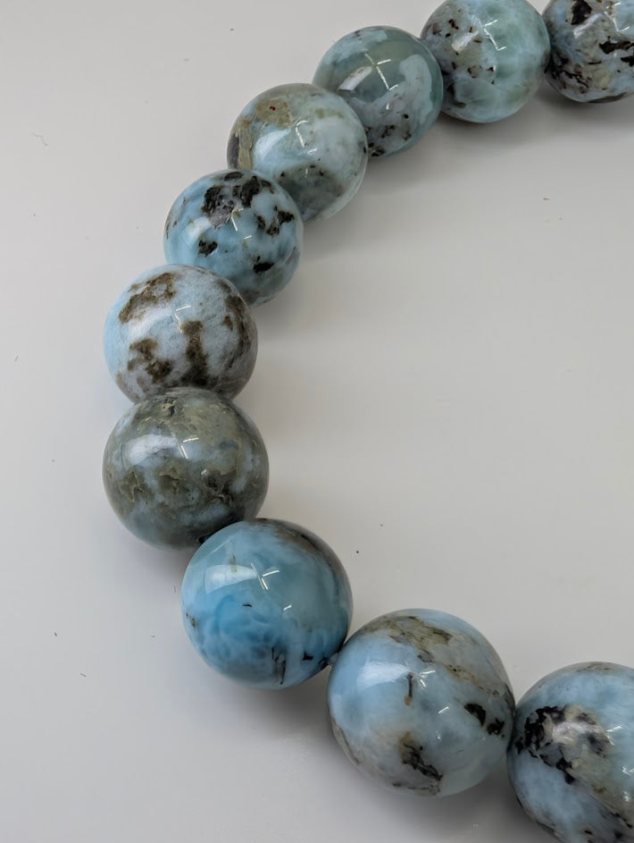 Detailed view of Larimar beads with earthy matrix and shine
