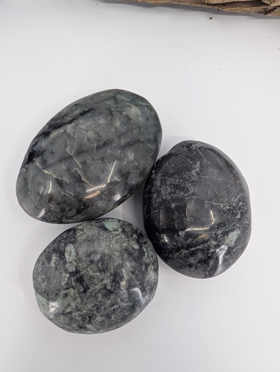 Close-up of polished larvikite palm stones showing grey feldspar patterning