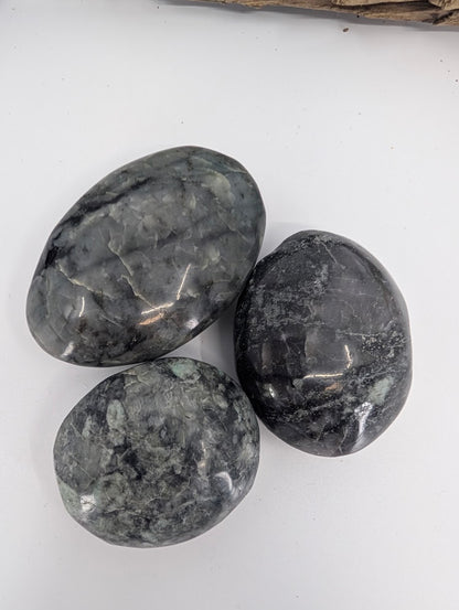 Close-up of polished larvikite palm stones showing grey feldspar patterning