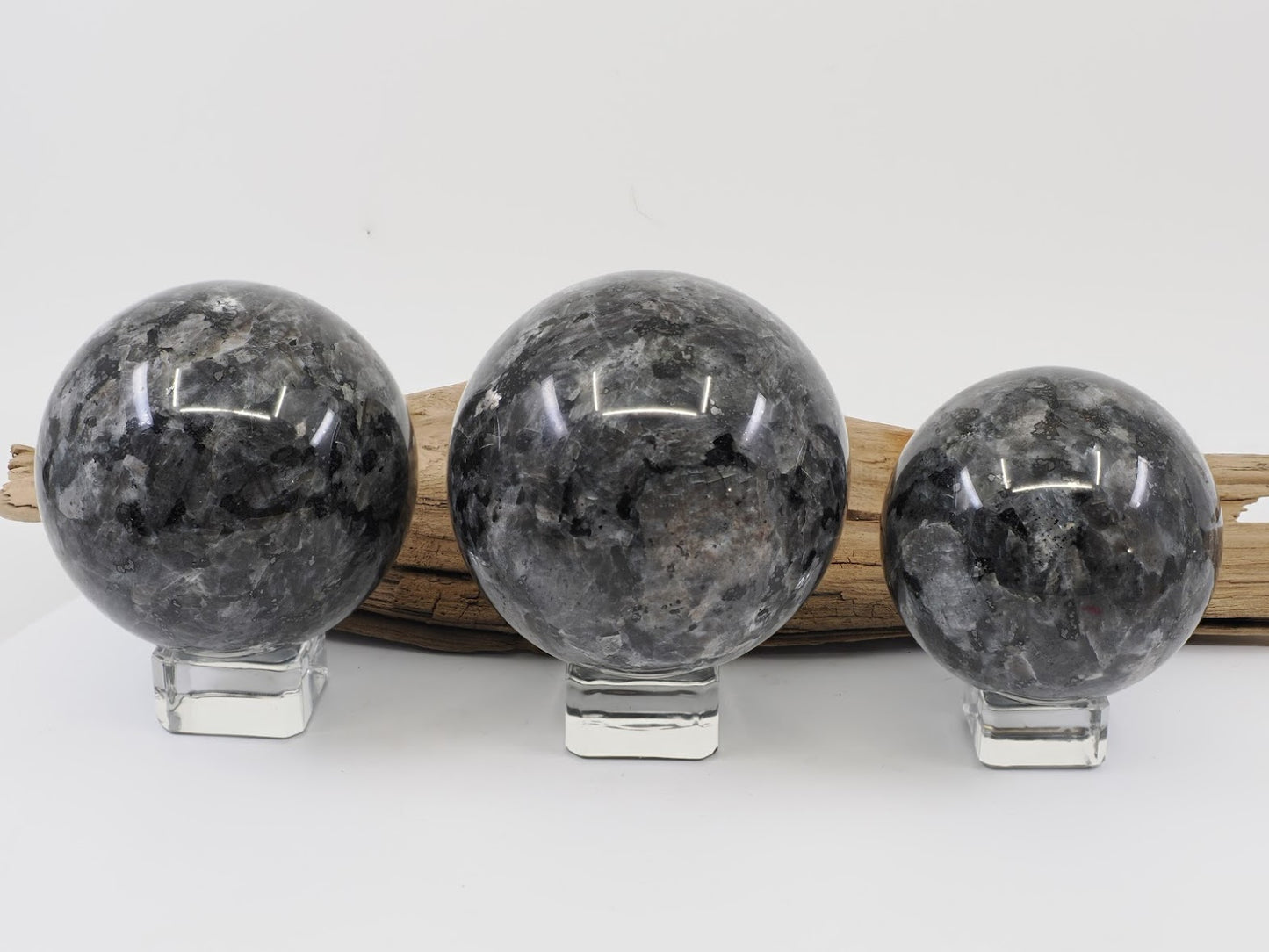 Size comparison of small medium and large Larvikite spheres with dark grey matrix.