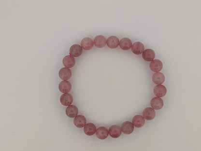 Flatlay of 8mm lavender rose quartz bracelet on neutral background