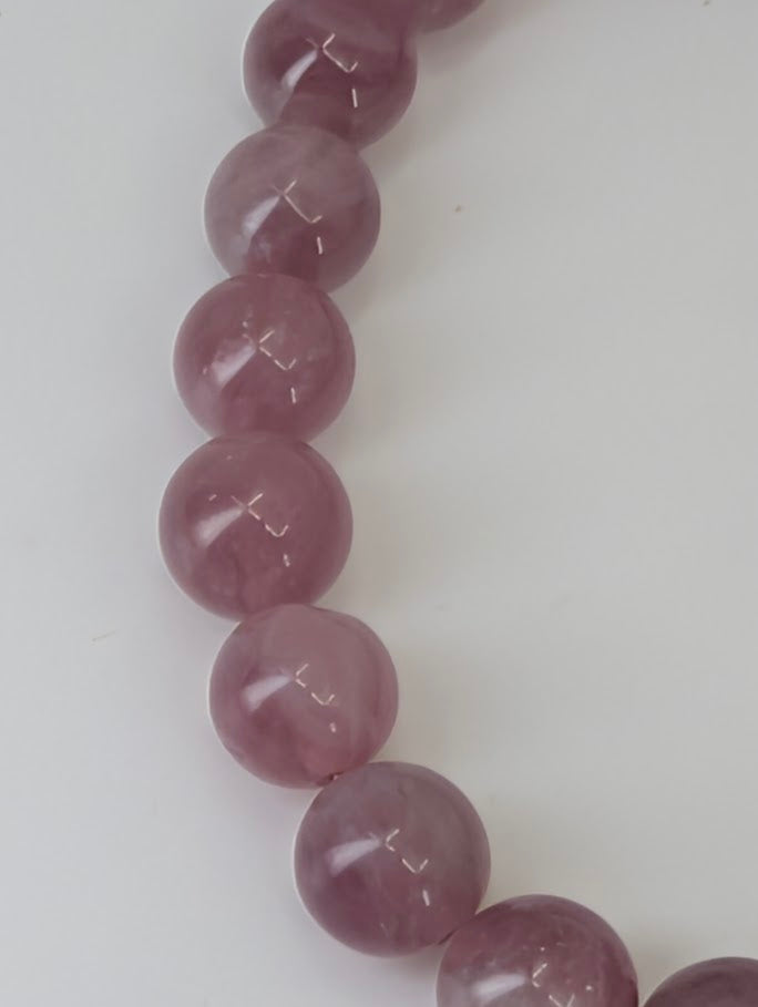 Detailed view of polished Lavender Rose Quartz bracelet showing smooth reflective finish