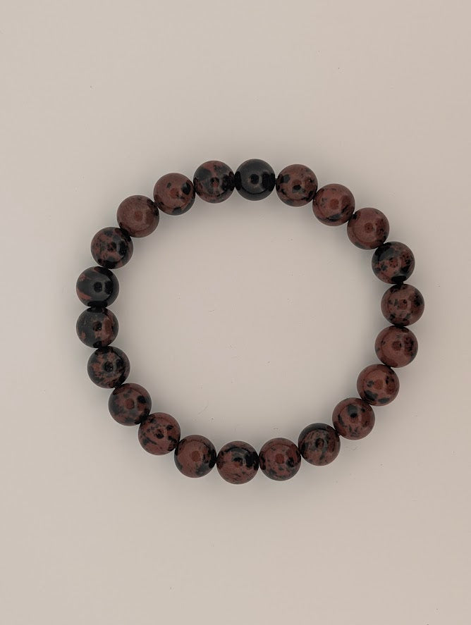 Flat lay of 8mm red obsidian stretch bracelet in a circle