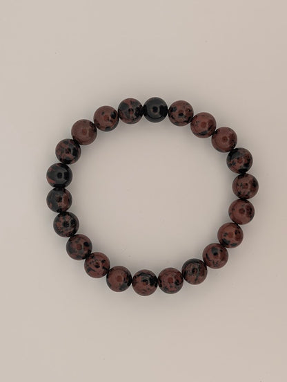 Flat lay of 8mm red obsidian stretch bracelet in a circle