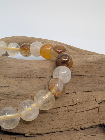 Macro of 8mm Golden Healer Quartz beads showing golden iron-oxide veils
