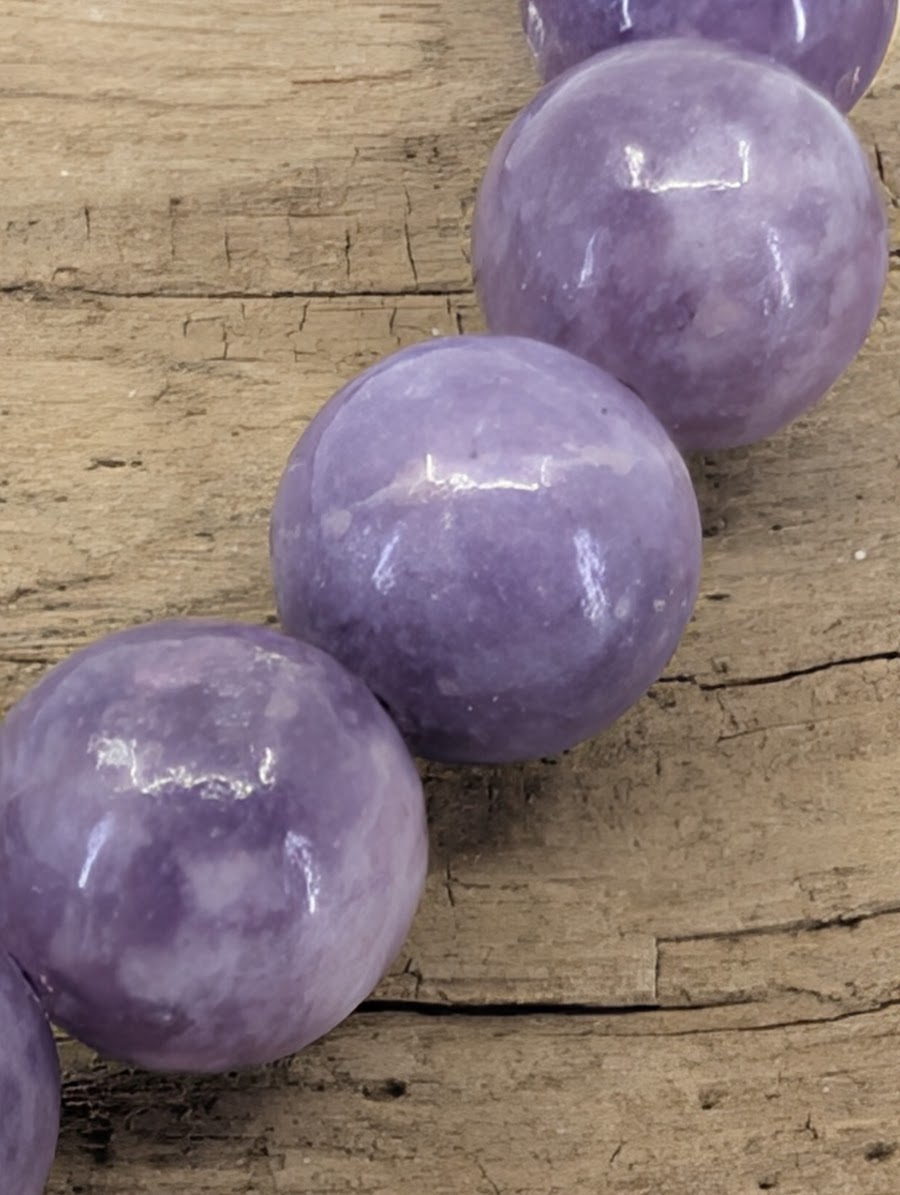 Macro view of 8mm Lepidolite beads showing natural micaceous flash and crystalline structures typical of Minas Gerais specimens.