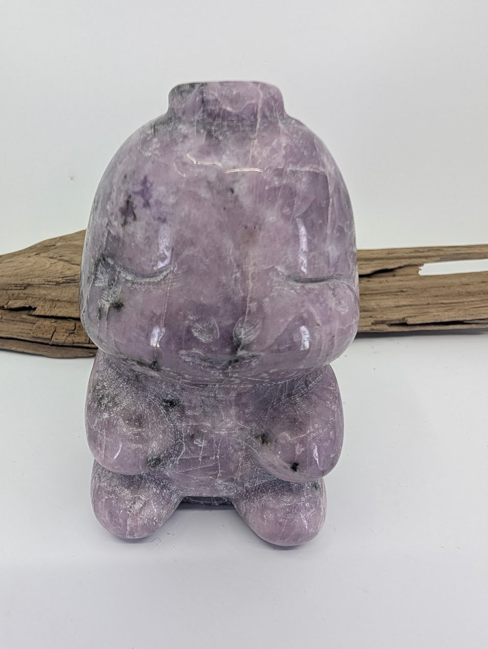 Front view of a hand-carved purple Lepidolite dinosaur specimen A from Brazil.