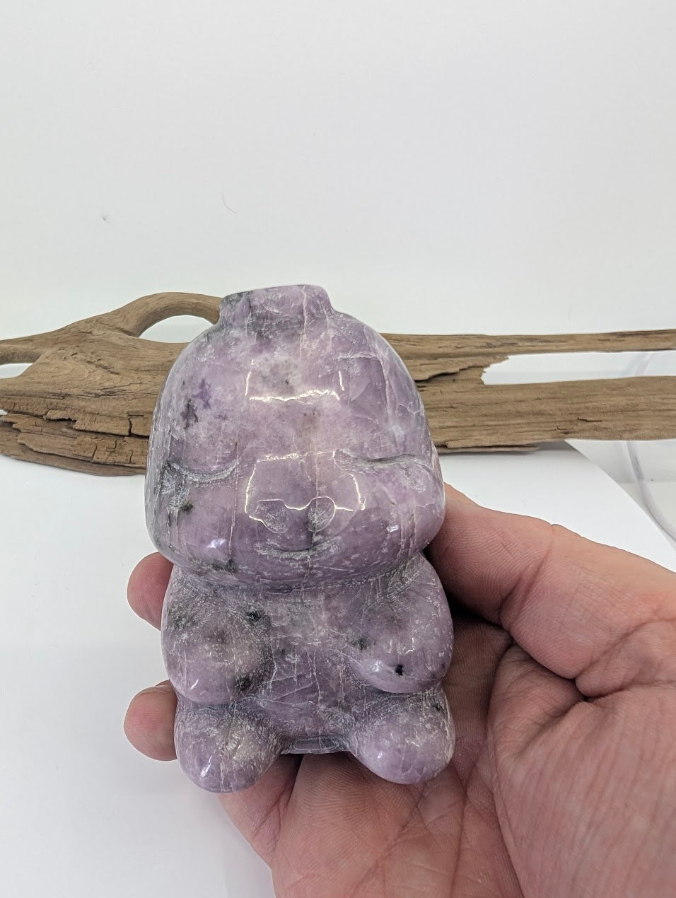 Hand-held view of the purple Lepidolite dinosaur providing a sense of scale and color saturation.