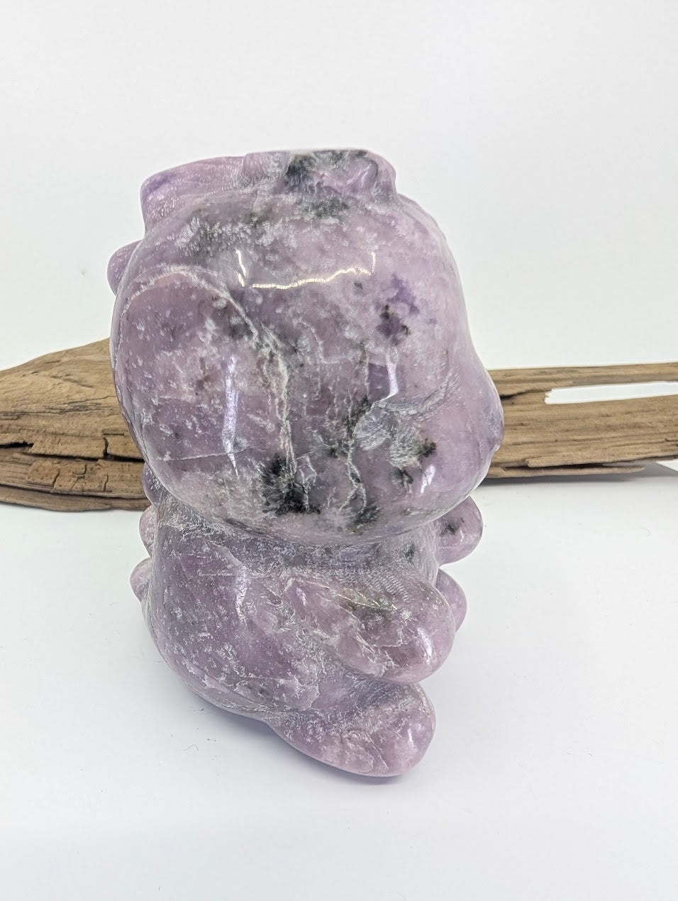 Hand-held view of the purple Lepidolite dinosaur providing a sense of scale and color saturation.