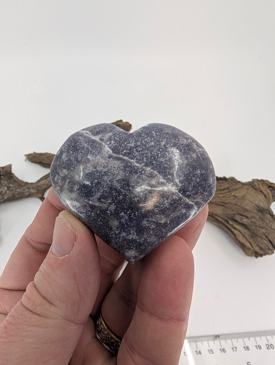 Hand holding a small 90g Lepidolite heart showing purple sparkles.