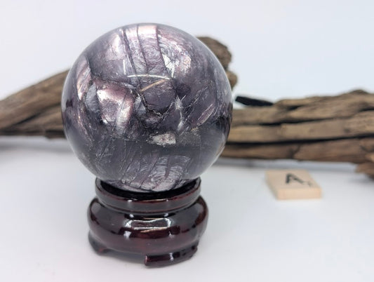 Brightly lit view of Sphere A showing glossy polish and purple crystal layers.