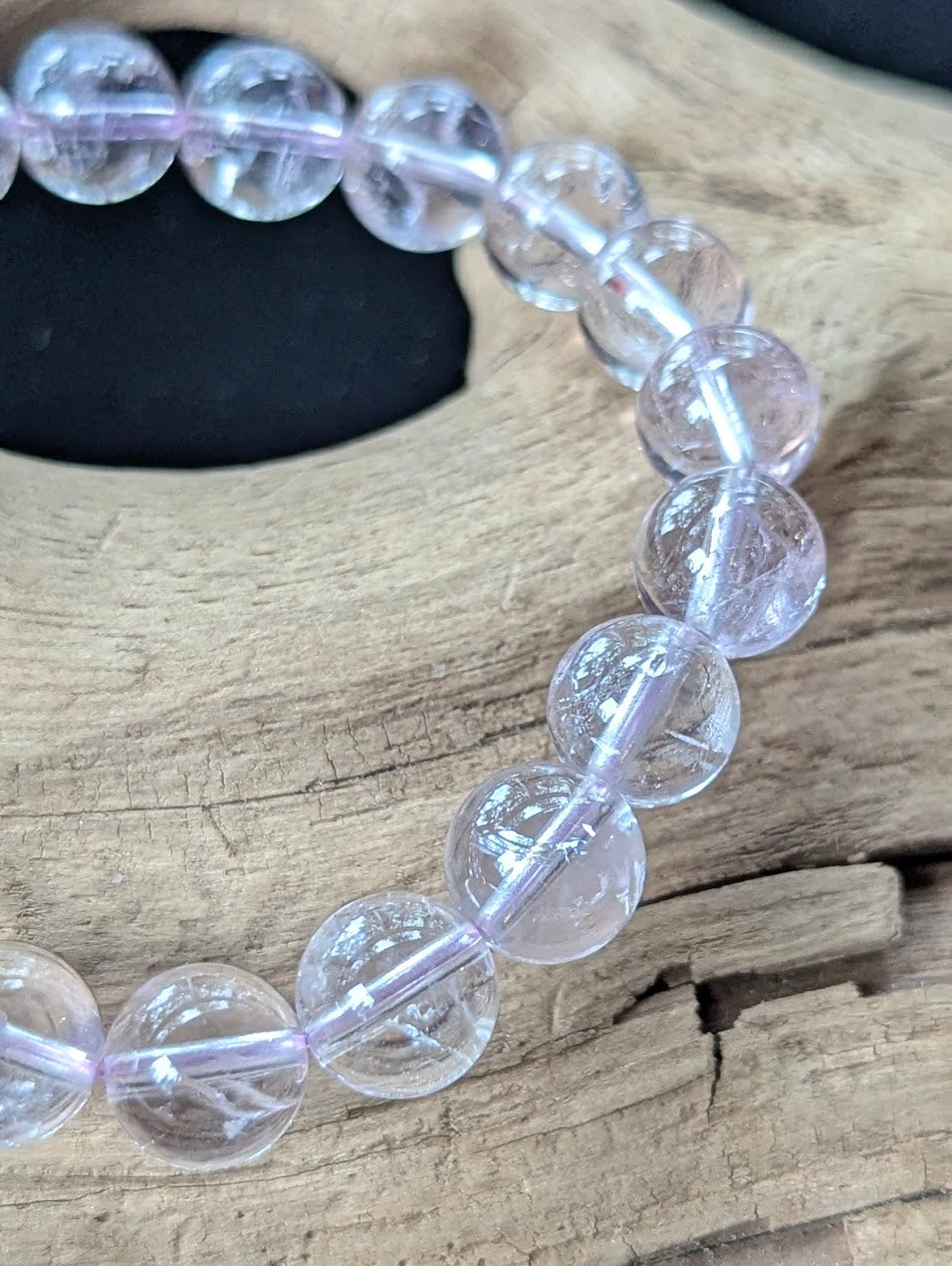 Macro detail shot of 10mm Bolivian Light Amethyst beads showing clean quartz structure and brilliant polish.