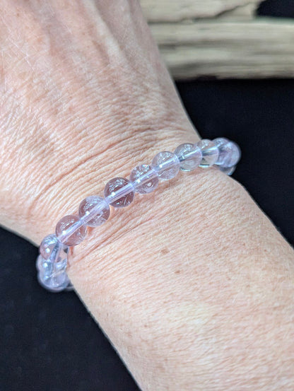7mm Light Amethyst beaded bracelet worn on a wrist, demonstrating a gentle pastel purple hue in natural lighting.