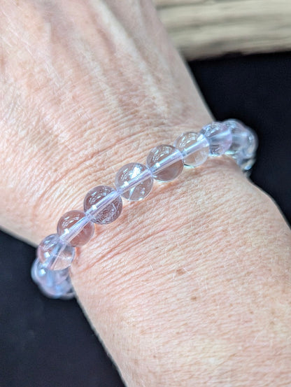 9mm Light Amethyst beaded bracelet worn on a wrist, catching the light to highlight its inner clarity.